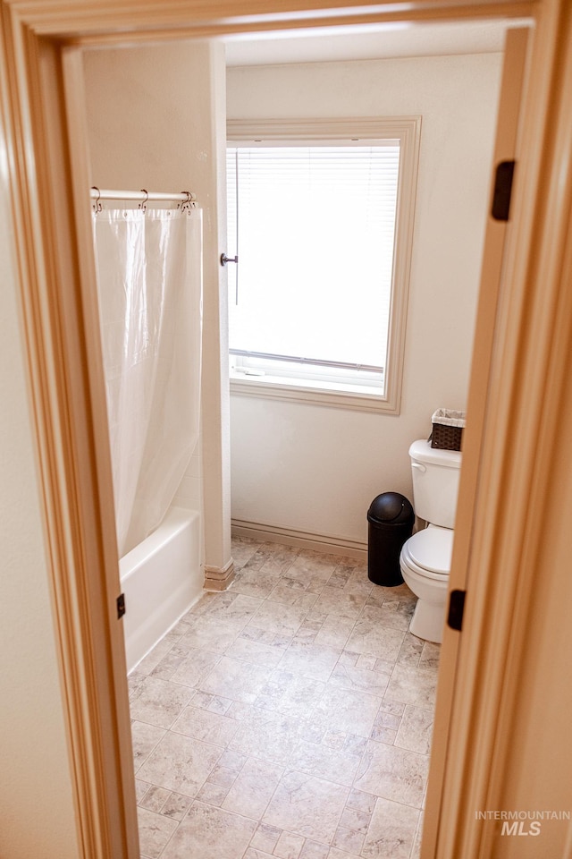 bathroom with shower / bath combo and toilet