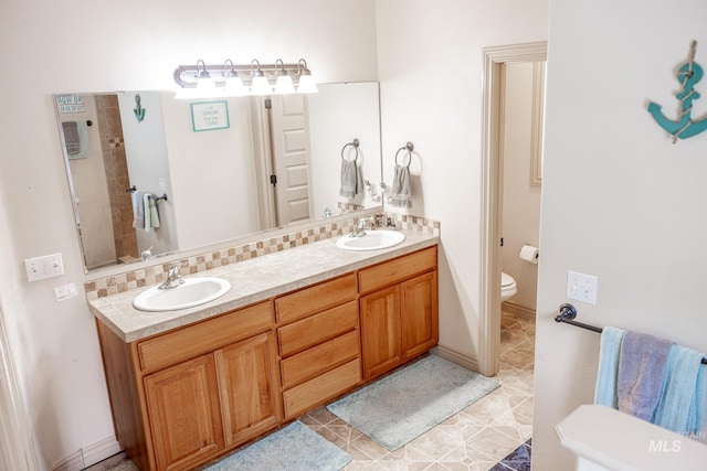 bathroom featuring decorative backsplash, vanity, toilet, and tile patterned flooring