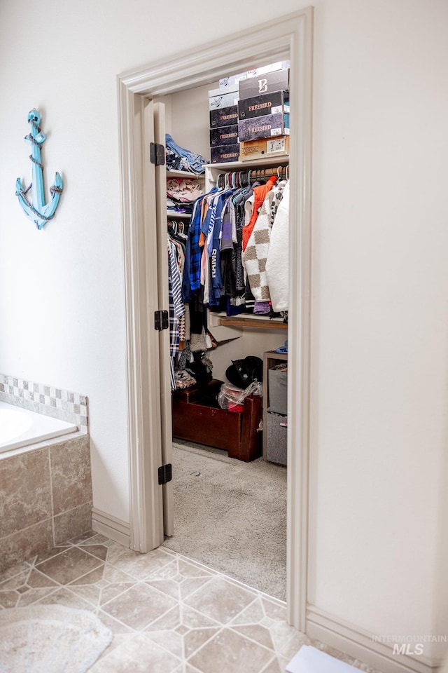 bathroom featuring tile patterned flooring and tiled tub