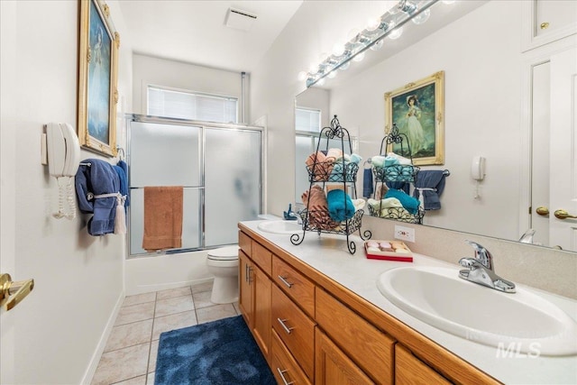 bathroom with a sink, bath / shower combo with glass door, tile patterned flooring, and double vanity