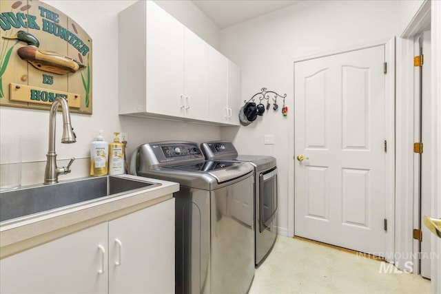 laundry area featuring a sink, cabinet space, and washing machine and clothes dryer