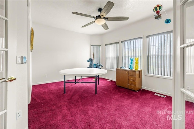 carpeted office with baseboards, a ceiling fan, and visible vents