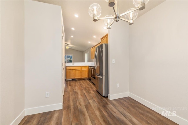 kitchen featuring dark wood-type flooring, light countertops, hanging light fixtures, range, and freestanding refrigerator