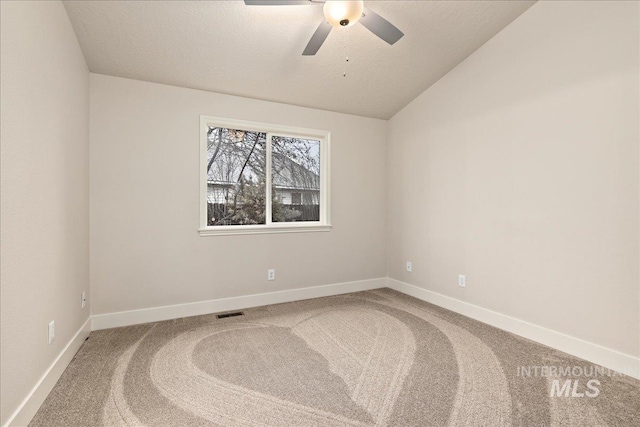 unfurnished room with carpet floors, visible vents, baseboards, and vaulted ceiling