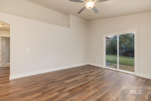 empty room with dark wood finished floors, baseboards, and ceiling fan