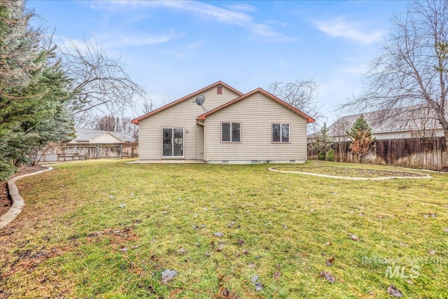 rear view of property with a lawn and a fenced backyard