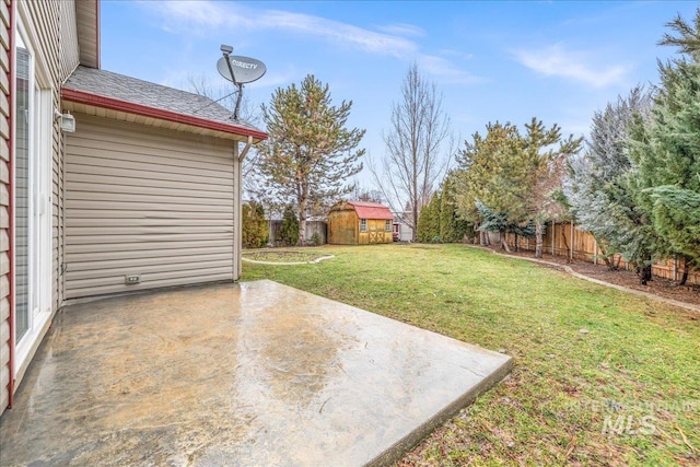 view of yard featuring a storage shed, a patio area, a fenced backyard, and an outdoor structure