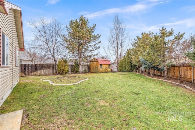 view of yard featuring a fenced backyard, a storage unit, and an outbuilding