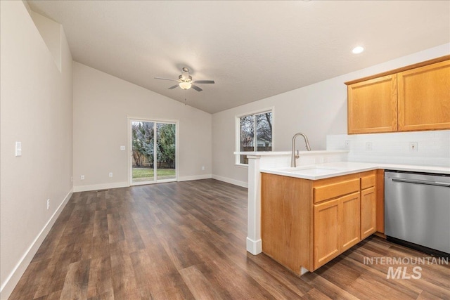 kitchen featuring light countertops, stainless steel dishwasher, open floor plan, a sink, and a peninsula