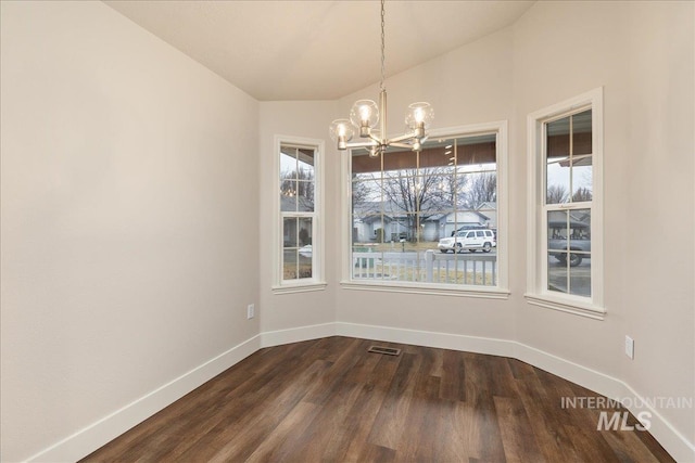 unfurnished dining area with a chandelier, dark wood-style flooring, visible vents, baseboards, and vaulted ceiling