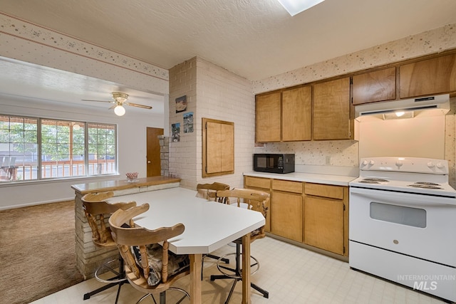 kitchen with ceiling fan, electric range, and a textured ceiling