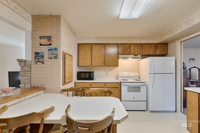 kitchen with a textured ceiling and white appliances