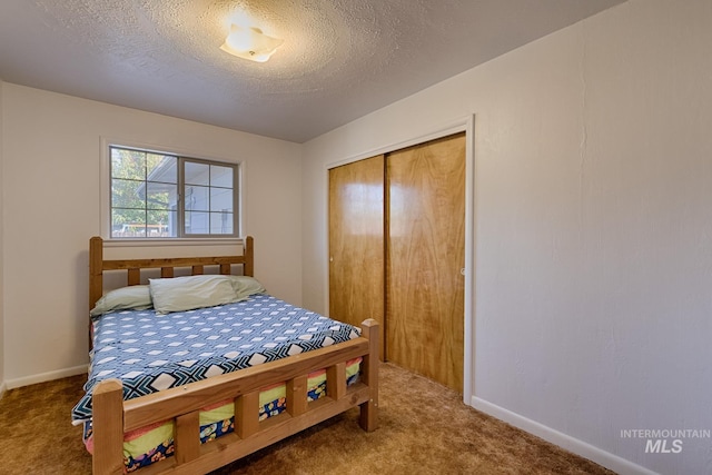 carpeted bedroom featuring a closet and a textured ceiling