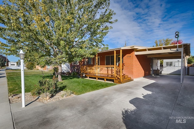 view of front of home featuring a front yard, a carport, and a porch