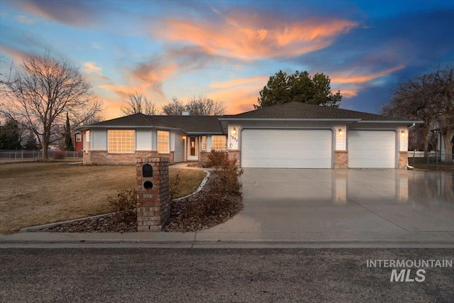 ranch-style house featuring brick siding, concrete driveway, an attached garage, a front yard, and fence