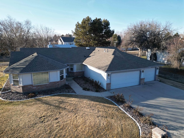 ranch-style home featuring an attached garage, brick siding, driveway, roof with shingles, and a front yard