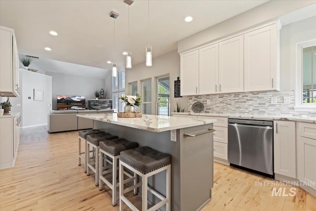 5915 N Lilybrook Pl, Boise, ID 83713 - kitchen featuring dishwasher, open floor plan, light wood-type flooring, decorative backsplash, and white cabinetry