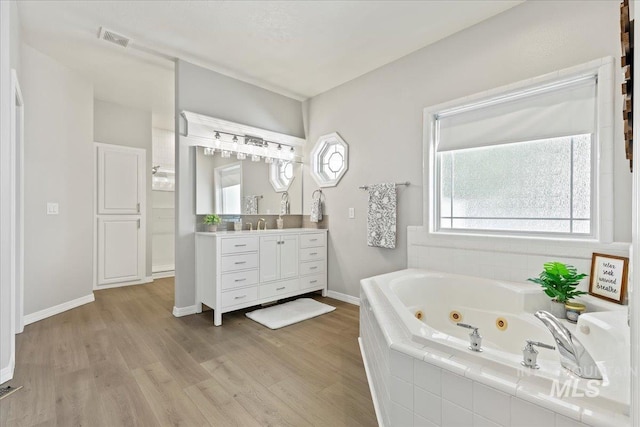 5915 N Lilybrook Pl, Boise, ID 83713 - full bathroom featuring vanity, a tub with jets, and wood finished floors