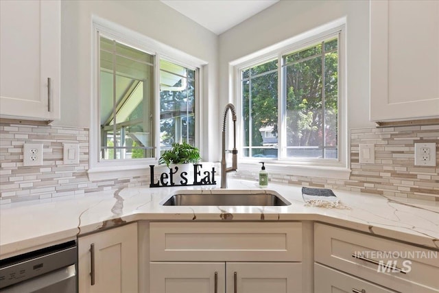 5915 N Lilybrook Pl, Boise, ID 83713 - kitchen with a sink, stainless steel dishwasher, white cabinetry, backsplash, and light stone countertops
