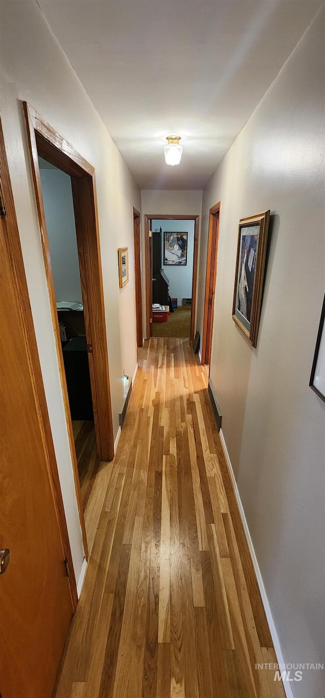 corridor with hardwood / wood-style flooring