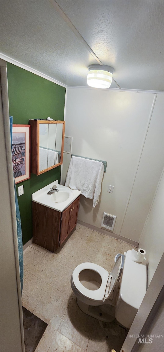 bathroom featuring a textured ceiling, vanity, and toilet