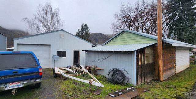 exterior space with a mountain view, a garage, and an outdoor structure