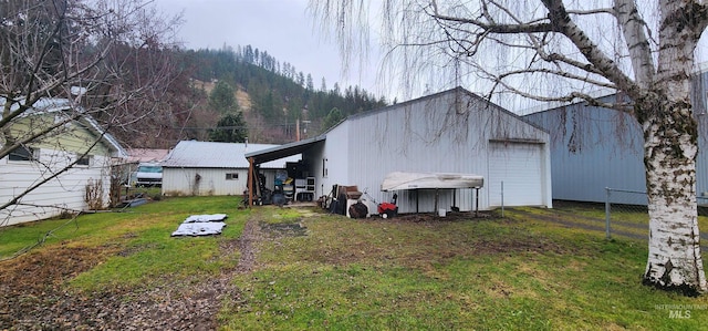 exterior space featuring a lawn, a mountain view, and a garage