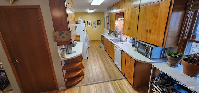 kitchen featuring sink, white appliances, and light wood-type flooring