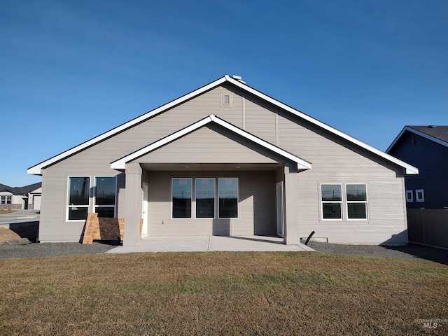 rear view of house featuring a patio, a lawn, and fence