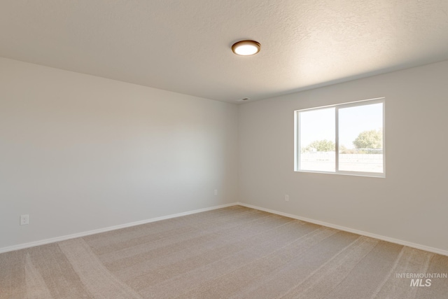 carpeted spare room with a textured ceiling