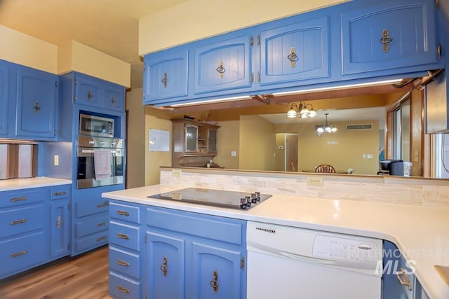 kitchen featuring blue cabinetry, tasteful backsplash, appliances with stainless steel finishes, and light countertops