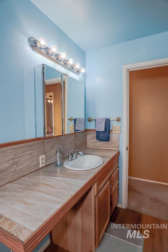 bathroom with decorative backsplash and vanity