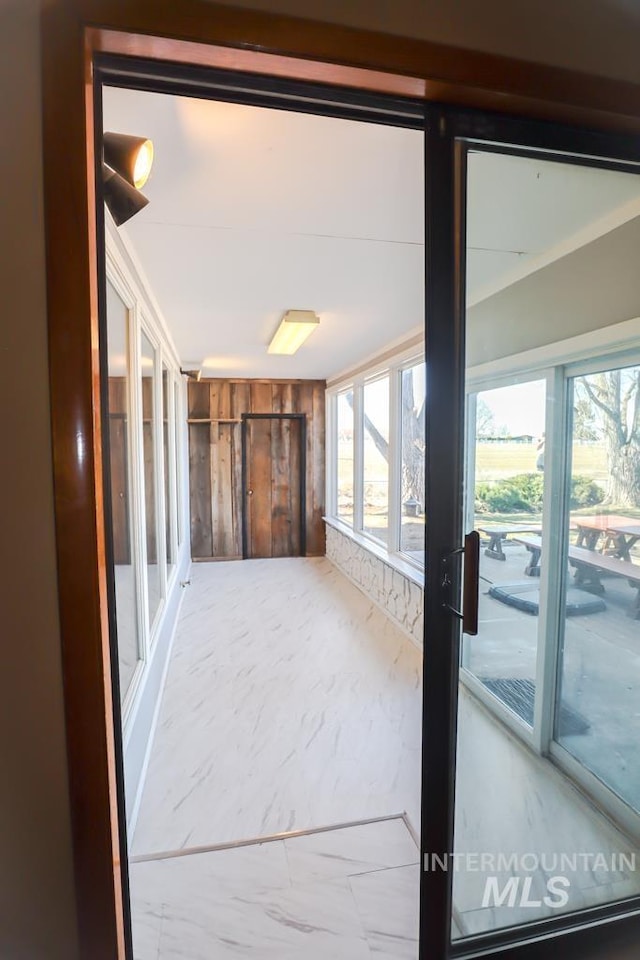 interior space with wooden walls and a healthy amount of sunlight