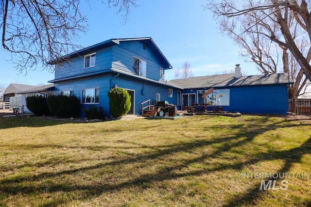 rear view of house featuring a yard and a wooden deck