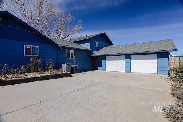 view of property exterior featuring cooling unit, an attached garage, driveway, and a shingled roof