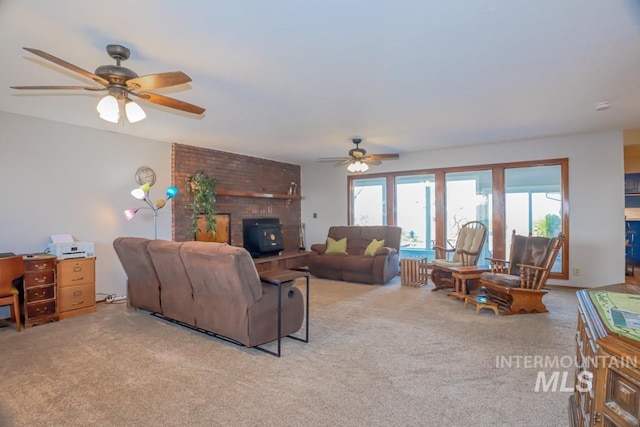 carpeted living area with ceiling fan and a wood stove