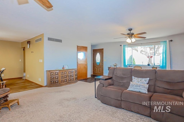 carpeted living area featuring visible vents, baseboards, and a ceiling fan