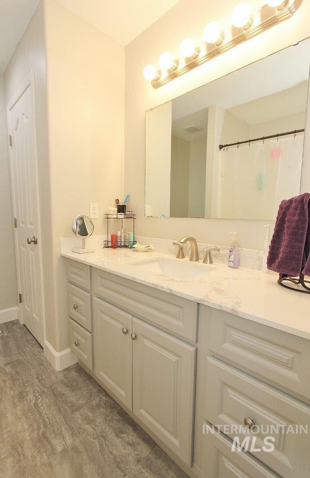 415 S Fern St, Nampa, ID 83686 - bathroom with baseboards, wood finished floors, and vanity