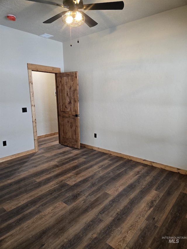 unfurnished room featuring ceiling fan and dark wood-type flooring