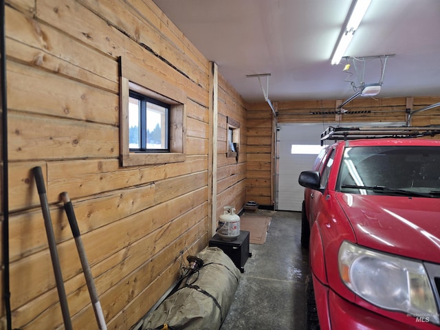 garage with a garage door opener and wooden walls