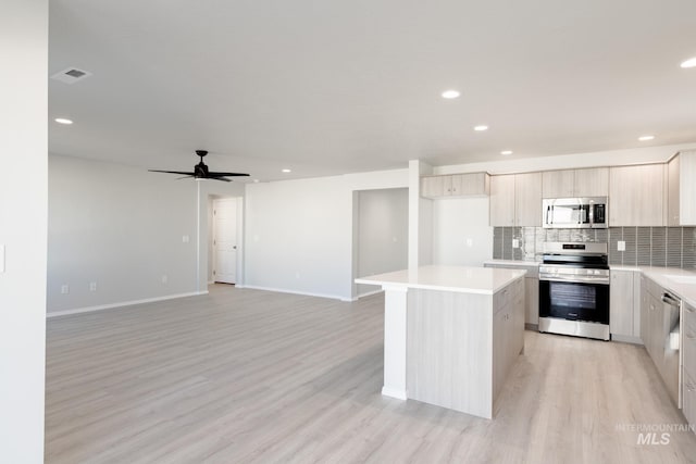 2059 N Thunderbolt St, Mountain Home, ID 83647 - kitchen featuring stainless steel appliances, a kitchen island, light countertops, tasteful backsplash, and recessed lighting