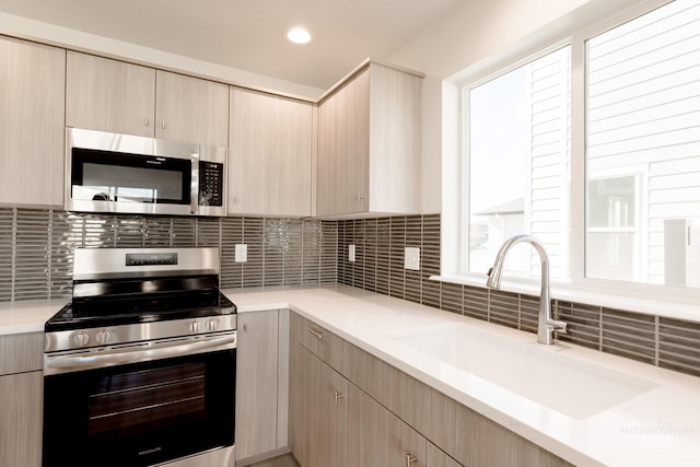 2059 N Thunderbolt St, Mountain Home, ID 83647 - kitchen featuring stainless steel appliances, a sink, light brown cabinets, light countertops, and tasteful backsplash