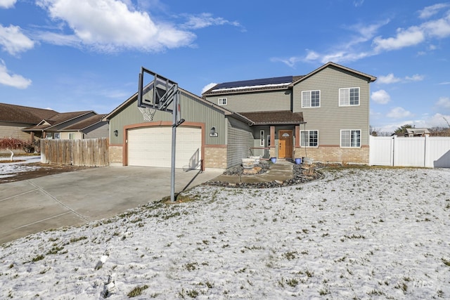 view of front of property featuring a garage and solar panels