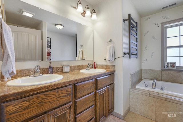 bathroom featuring tile patterned floors, vanity, and tiled tub