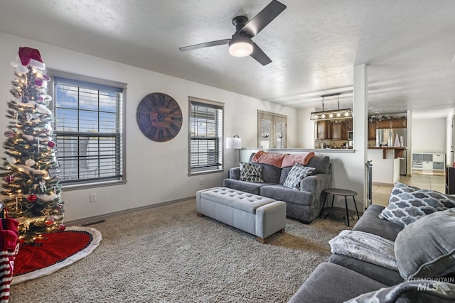 living room with ceiling fan, carpet floors, a textured ceiling, and french doors