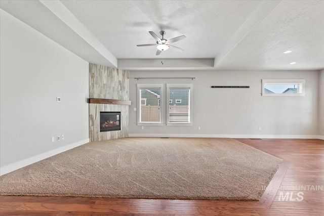 15343 Moss Creek Way, Caldwell, ID 83607 - unfurnished living room with a ceiling fan, baseboards, plenty of natural light, a fireplace, and a textured ceiling
