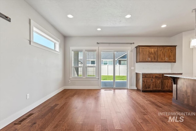 15343 Moss Creek Way, Caldwell, ID 83607 - kitchen with baseboards, dark wood-style floors, recessed lighting, tasteful backsplash, and pendant lighting