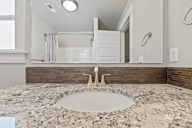 15343 Moss Creek Way, Caldwell, ID 83607 - full bath featuring decorative backsplash, a shower with curtain, and vanity