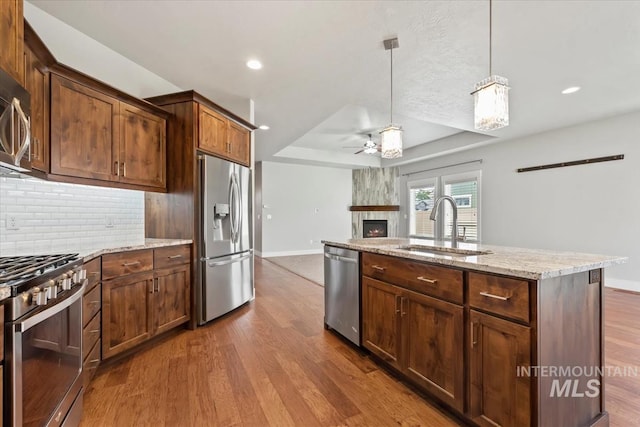 15343 Moss Creek Way, Caldwell, ID 83607 - kitchen with stainless steel appliances, a raised ceiling, a sink, baseboards, and dark wood finished floors