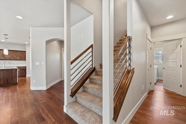 15343 Moss Creek Way, Caldwell, ID 83607 - stairway featuring arched walkways, hardwood / wood-style flooring, recessed lighting, baseboards, and washer / clothes dryer